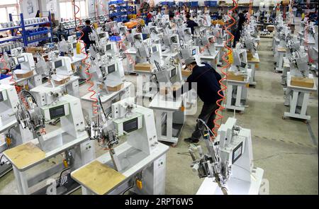 200412 -- QINGDAO, 12. April 2020 -- Arbeiter arbeiten Überstunden, um Nahtversiegelungsausrüstung für Schutzkleidung in der Werkstatt von Nawon Machinery Co., Ltd. Im Jimo-Bezirk von Qingdao, ostchinesische Provinz Shandong, 11. April 2020 zu produzieren. Seit seiner Wiederaufnahme der Produktion am 7. Februar stellt die in Südkorea investierte Nawon Machinery Co., Ltd. Mit voller Geschwindigkeit die Nähdichtausrüstung für Schutzkleidung her, eine notwendige, aber nicht in Massenproduktion hergestellte Ausrüstung, die aufgrund der weltweiten Ausbreitung der COVID-19-Pandemie knapp ist. CHINA-QINGDAO-COVID-19-SÜDKOREANISCHES UNTERNEHMEN-SEAM SE Stockfoto