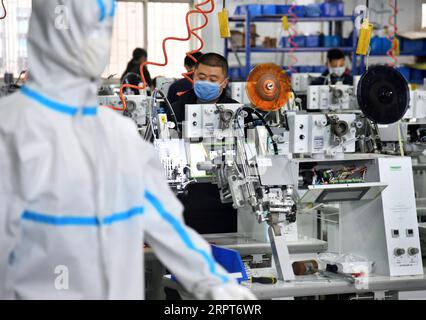 200412 -- QINGDAO, 12. April 2020 -- Arbeiter arbeiten Überstunden, um Nahtversiegelungsausrüstung für Schutzkleidung in der Werkstatt von Nawon Machinery Co., Ltd. Im Jimo-Bezirk von Qingdao, ostchinesische Provinz Shandong, 11. April 2020 zu produzieren. Seit seiner Wiederaufnahme der Produktion am 7. Februar stellt die in Südkorea investierte Nawon Machinery Co., Ltd. Mit voller Geschwindigkeit die Nähdichtausrüstung für Schutzkleidung her, eine notwendige, aber nicht in Massenproduktion hergestellte Ausrüstung, die aufgrund der weltweiten Ausbreitung der COVID-19-Pandemie knapp ist. CHINA-QINGDAO-COVID-19-SÜDKOREANISCHES UNTERNEHMEN-SEAM SE Stockfoto