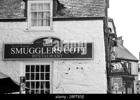 Pubs und Restaurants in dieser alten, weiß getünchten Bucht sind treffende Namen, die die Schmuggelgeschichte des Dorfes widerspiegeln Stockfoto