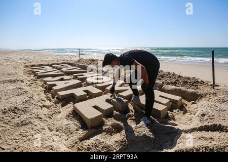 200412 -- GAZA, 12. April 2020 Xinhua -- Ein palästinensischer Künstler schnitzt Worte BLEIBEN SIE ZU HAUSE BLEIBEN SIE SICHER mit Sand an einem Strand in Gaza City, am 12. April 2020. Palästina sagte am Sonntag, dass die Gesamtzahl der COVID-19-Fälle im Land 290 erreicht hat. Foto von Rizek Abdeljawad/Xinhua MIDEAST-GAZA STADT-COVID-19-SAND ART PUBLICATIONxNOTxINxCHN Stockfoto