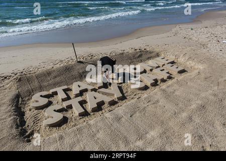 200412 -- GAZA, 12. April 2020 Xinhua -- Ein palästinensischer Künstler schnitzt Worte BLEIBEN SIE ZU HAUSE BLEIBEN SIE SICHER mit Sand an einem Strand in Gaza City, am 12. April 2020. Palästina sagte am Sonntag, dass die Gesamtzahl der COVID-19-Fälle im Land 290 erreicht hat. Foto von Rizek Abdeljawad/Xinhua MIDEAST-GAZA STADT-COVID-19-SAND ART PUBLICATIONxNOTxINxCHN Stockfoto