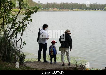 200413 -- WUHAN, 13. April 2020 -- Eine Familie genießt den Blick auf den Donghu Greenway in Wuhan, zentralchinesische Provinz Hubei, 13. April 2020. Als die Coronavirus-Epidemie abnimmt, kommen immer mehr Menschen nach Donghu Greenway, um den Frühling zu genießen. CHINA-HUBEI-WUHAN-GREENWAY CN ChengxMin PUBLICATIONxNOTxINxCHN Stockfoto