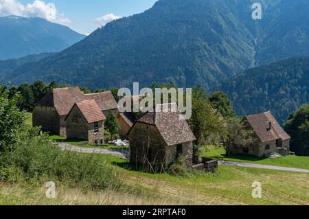 Blick auf den antiken Ortsteil Orias in der Nähe von Pesariis in Norditalien mit den „stavoli“, ländlichen Bauten, die in der Vergangenheit von Landwirten und Züchtern genutzt wurden Stockfoto