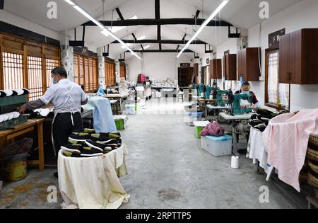 200418 -- CHENGDU, 18. April 2020 -- Arbeiter machen handgefertigte Schuhe im Dorf Zhanqi der Gemeinde Tangchang in Chengdu, südwestchinesische Provinz Sichuan, 17. April 2020. Lai Shufang, 62, ist seit über 40 Jahren in der Herstellung von handgefertigten Tangchang-Schuhen tätig. In Tangchang Township ist Lais Familie die einzige, die noch Tangchang Stoffschuhe herstellt, die vor ihrer Fertigstellung 32 Verfahren umfassen. Wie viele Handwerker war Lai einst besorgt, dass das Handwerk ausbleiche und es keine Erben gäbe. Das Handwerk bot jedoch die Gelegenheit, zu gedeihen, als es als p aufgeführt wurde Stockfoto