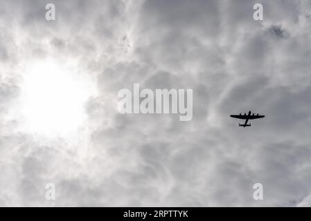 Avro Lancaster vom Battle of Britain Memorial Flight fliegt in einem stimmungsvollen Himmel gegen die Sonne. Himmelskonzept Stockfoto