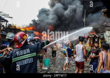 200418 -- MANILA, 18. April 2020 Xinhua -- Feuerwehrleute versuchen, ein Feuer zu löschen, das ein Slum-Gebiet in Manila, Philippinen, erfasst, 18. April 2020. Hunderte Familien wurden am Samstag wegen des Feuers vertrieben. Xinhua/Rouelle Umali PHILIPPINEN-MANILA-SLUM-FIRE PUBLICATIONxNOTxINxCHN Stockfoto