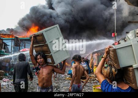 200418 -- MANILA, 18. April 2020 Xinhua -- Bewohner tragen ihre Habseligkeiten, die von einem Feuer in einem Slumgebiet in Manila, Philippinen, gerettet wurden, 18. April 2020. Hunderte Familien wurden am Samstag wegen des Feuers vertrieben. Xinhua/Rouelle Umali PHILIPPINEN-MANILA-SLUM-FIRE PUBLICATIONxNOTxINxCHN Stockfoto