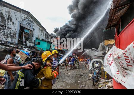 200418 -- MANILA, 18. April 2020 Xinhua -- Feuerwehrleute versuchen, ein Feuer zu löschen, das ein Slum-Gebiet in Manila, Philippinen, erfasst, 18. April 2020. Hunderte Familien wurden am Samstag wegen des Feuers vertrieben. Xinhua/Rouelle Umali PHILIPPINEN-MANILA-SLUM-FIRE PUBLICATIONxNOTxINxCHN Stockfoto