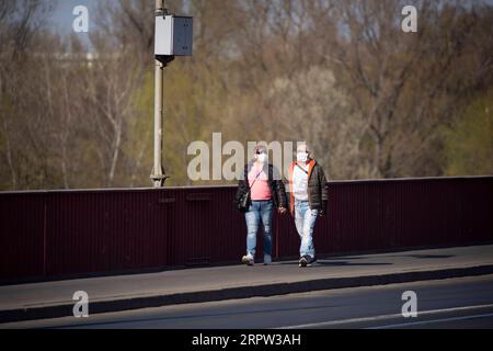 200421 -- WARSCHAU, 21. April 2020 Xinhua -- Fußgänger mit Gesichtsmasken gehen am 20. April 2020 auf der Dabrowski-Brücke in Warschau, Polen. Die polnische Regierung hat einige Beschränkungen im Zusammenhang mit der COVID-19-Pandemie am Montag aufgehoben, Wälder und Parks für die Öffentlichkeit wieder geöffnet und es den Geschäften ermöglicht, mehr Kunden in ihren Räumlichkeiten zu empfangen. Foto von Jaap Arriens/Xinhua POLAND-WARSAW-COVID-19-RESTRIKTIONEN PUBLICATIONxNOTxINxCHN Stockfoto