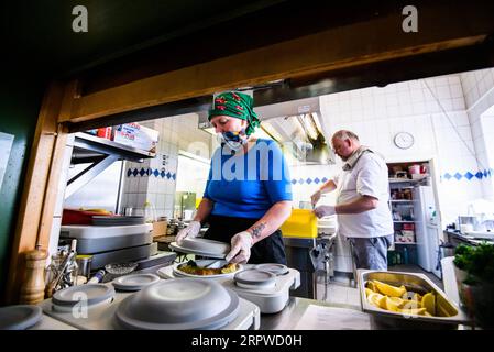 200425 -- ROSENHEIM, 25. April 2020 Xinhua -- Michael Haldek R und Christine Haldek, Eigentümer des Restaurants Fischkueche, bereiten kostenlose Mahlzeiten in der Küche des Restaurants in Rosenheim, Süddeutschland, 24. April 2020 zu. Als die COVID-19-Pandemie die süddeutsche Stadt Rosenheim heimsuchte, hat Fischkueche Fish Kitchen, ein Restaurant mit einer Geschichte von mehr als 100 Jahren, in den letzten fünf Wochen fast 2.000 kostenlose Mahlzeiten mit kostenloser Lieferung von Freiwilligen an hilfsbedürftige Menschen vor Ort bereitgestellt. Foto von Kevin Voigt/Xinhua GERMANY-ROSENHEIM-COVID-19-FREE MEALS PUBLICATIONxNOTxINxCHN Stockfoto