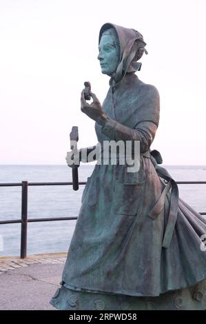 Bronzestatue der Pionierpaläontologin und Fossilienjägerin Mary Anning 1799-1847. Von der Bildhauerin Denise Dutton. Lyme Regis, Dorset, Jurassic Coast. Stockfoto