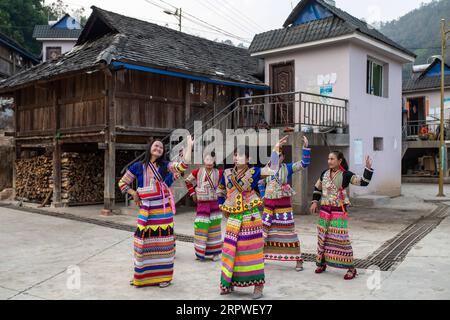 200426 -- MENGHAI, 26. April 2020 -- Frauen der Lahu-Volksgruppe tanzen im Dorf Manbansandui im Menghai County, Provinz Yunnan im Südwesten Chinas, 10. April 2020. Weit entfernt in den Bergen des südwestlichen chinesischen Yunnan liegt der ehemalige Ort des armutsgeplagten Ortsteils Manbansandui, in dem 17 Haushalte der ethnischen Gruppe Lahu lebten. Unter Berücksichtigung der Lebensgewohnheiten und Gebräuche der Dorfbewohner wurde der Weiler 2009 in ein neues Gebiet umgesiedelt, das an seinen ursprünglichen Standort angrenzt, um die Lebensumwelt der Dorfbewohner zu verbessern und die Armut abzuschütteln. Zusätzlich zum Infrastrukturprojekt Stockfoto