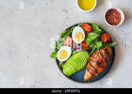Teller mit gebackenem Hähnchenfilet mit Speck, frischem Gemüse, Salat. Stockfoto