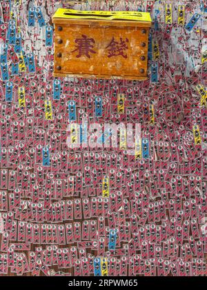 tokio, japan - nov 29 2022: Textur einer Wand eines Japan National Lottery Shops, voll bedeckt von Votivstreifen namens senjafuda mit einer Zeichnung eines von Stockfoto