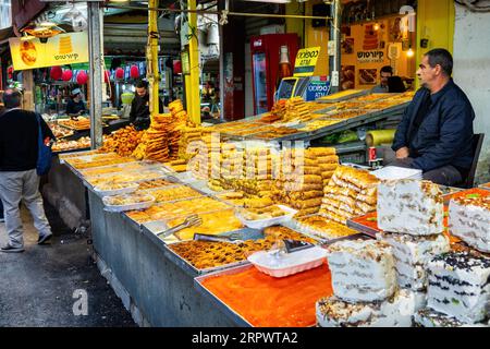 Der Anbieter verkauft süßes Gebäck auf dem Carmel Market in Tel Aviv, Israel. Stockfoto