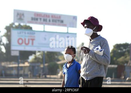 200505 -- HARARE, 5. Mai 2020 Xinhua -- zwei Kinder mit Gesichtsmasken gehen auf einer Straße in Harare, Simbabwe, 4. Mai 2020. Der simbabwische Präsident Emmerson Mnangagwa verlängerte am 1. Mai eine Sperrung, um die Ausbreitung von COVID-19 bis zum 17. Mai um zwei weitere Wochen einzudämmen. Die Polizei in Simbabwe wird ab Montag jeden verhaften, der seine Häuser verlässt, ohne Gesichtsmasken zu tragen. Foto von Shaun Jusa/Xinhua ZIMBABWE-HARARE-LOCKDOWN-EXTENSION PUBLICATIONxNOTxINxCHN Stockfoto