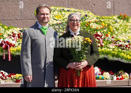 200505 -- RIGA, 5. Mai 2020 -- Ein Paar in lettischen Nationalkostümen posiert für ein Foto, während es Blumen auf das Freiheitsdenkmal in Riga, Lettland, legt, am 4. Mai 2020, während das Land den 30. Jahrestag seiner Unabhängigkeitserklärung feiert. Der 4. Mai wird von den Letten anlässlich des Tages gefeiert, an dem das Land 1990 die Unabhängigkeit von der ehemaligen Sowjetunion erklärte. Aufgrund der COVID-19-Pandemie fanden in diesem Jahr landesweite Feiern meist zu Hause statt, da alle jährlichen Veranstaltungen abgesagt wurden. Foto von /Xinhua LETTLAND-RIGA-COVID-19-UNABHÄNGIGKEITSERKLÄRUNG-JAHRESTAG JanisxLaizans VERÖFFENTLICHUNG Stockfoto