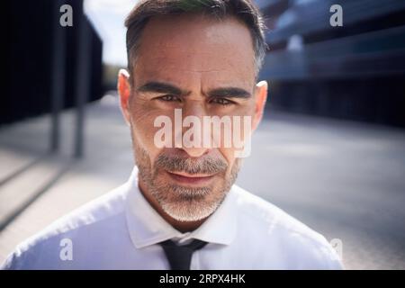 Nahaufnahme eines ernsthaften Reifen Mannes, der auf eine Kamera schaut, die vor dem Geschäftsgebäude steht. Leerzeichen kopieren. Stockfoto
