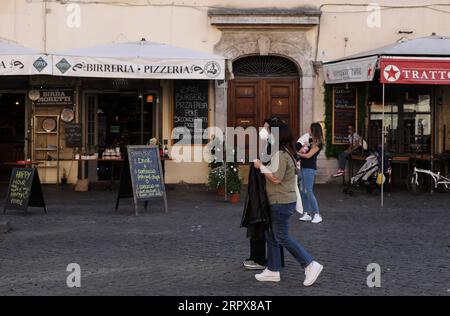 200513 -- ROM, 13. Mai 2020 -- Menschen, die Gesichtsmasken tragen, gehen an Restaurants vorbei, die zum Mitnehmen in Rom, Italien, 12. Mai 2020, wiedereröffnet wurden. ZU FOLGENDEM: Italien COVID-19-Fälle sinken als Länder für wirtschaftlichen Rückgang ITALIEN-ROM-COVID-19-FÄLLE ChengxTingting PUBLICATIONxNOTxINxCHN Stockfoto