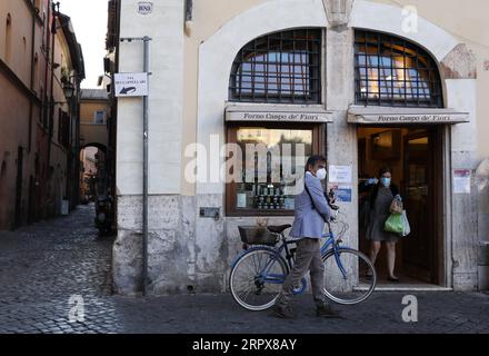 200513 -- ROM, 13. Mai 2020 -- Eine Frau, die Eine Gesichtsmaske trägt, verlässt ein Geschäft in Rom, Italien, 12. Mai 2020. ZU FOLGENDEM: Italien COVID-19-Fälle sinken als Länder für wirtschaftlichen Rückgang ITALIEN-ROM-COVID-19-FÄLLE ChengxTingting PUBLICATIONxNOTxINxCHN Stockfoto