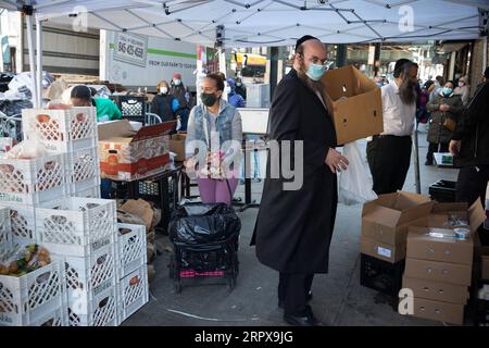 200515 -- NEW YORK, 15. Mai 2020 Xinhua -- Menschen wählen Lebensmittel an einem Lebensmittelvertrieb im Brooklyn Borough von New York, USA, 14. Mai 2020. Die Zahl der ersten arbeitslosen Anträge in den USA lag letzte Woche bei 2.981.000. Foto von Michael Nagle/Xinhua U.S.-COVID-19-JOBLESS CLAIMS PUBLICATIONxNOTxINxCHN Stockfoto