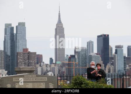 200519 -- NEW YORK, 19. Mai 2020 -- Menschen, die Gesichtsmasken tragen, machen Fotos mit der Skyline von Manhattan aus Weehawken in New Jersey, USA, 18. Mai 2020. Die Zahl der COVID-19-Fälle in den Vereinigten Staaten erreichte am Montag 1,5 Millionen und erreichte 1.500.753 bis 16:03 Uhr 2003 GMT, so das Center for Systems Science and Engineering CSSE an der Johns Hopkins University. Unterdessen stieg die Zahl der nationalen Todesopfer von COVID-19 auf 90.312, so die CSSE. US-COVID-19-FÄLLE WangxYing PUBLICATIONxNOTxINxCHN Stockfoto