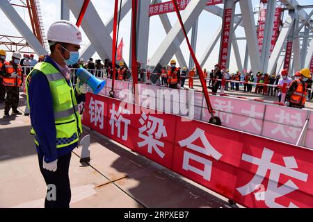 200519 -- ZHENGZHOU, 19. Mai 2020 -- Arbeiter werden auf der Baustelle einer Brücke über den Gelben Fluss in Zhengzhou, der zentralchinesischen Provinz Henan, am 19. Mai 2020 gesehen. Die 2016 Meter lange Brücke schloss sich am Dienstag zusammen. Das obere Stockwerk ist eine sechsspurige Schnellstraße, während das untere Stockwerk eine vierspurige Eisenbahn ist. Die Brücke ist ein Teil der Eisenbahnstrecke von Zhengzhou nach Jinan, der ostchinesischen Provinz Shandong. CHINA-ZHENGZHOU-JINAN-RAILWAY-BRIDGE-CONSTRUCTION CN ZHUXXIANG PUBLICATIONXNOTXINXCHN Stockfoto