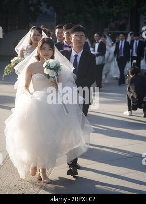 200519 -- NANJING, 19. Mai 2020 -- Paare bereiten sich darauf vor, Hochzeitsfotos in Nanjing, der ostchinesischen Provinz Jiangsu, zu machen, 19. Mai 2020. Insgesamt 15 Paare machten am Dienstag vor ihrer Gruppenhochzeit am 20. Mai Hochzeitsfotos in Nanjing. Einige der frisch verheirateten Personen sind medizinische Fachkräfte, die ihre Hochzeiten aufgrund ihrer Beteiligung am Kampf gegen die COVID-19-Pandemie verschoben haben. CHINA-JIANGSU-NANJING-GRUPPE HOCHZEITSFOTOS CN JIXCHUNPENG PUBLICATIONXNOTXINXCHN Stockfoto