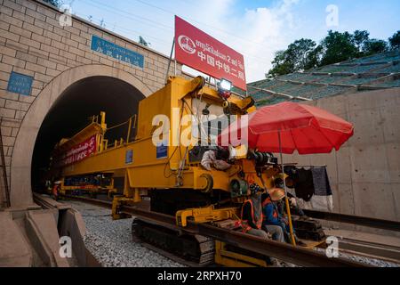 200523 -- PROVINZ VIENTIANE LAOS, 23. Mai 2020 Xinhua -- Laos und chinesische Arbeiter und Ingenieure der China Railway No. 2 Engineering Group arbeiten zusammen, um die Gleise durch den Ban Nong Khay Tunnel in der Provinz Vientiane, etwa 60 km nördlich der Hauptstadt Vientiane, Laos, am 23. Mai 2020 zu verlegen. Da jede Reihe von 14 Zementschwellen in der vorgeschriebenen Entfernung glatt über den Ban Nong Khay Tunnel fuhr und dann die 500 Meter langen Gleise genau durch den Ingenieurzug auf den Schwellen niedergelassen wurden, haben die Gleise der China-Laos Railway am Samstag ihren ersten Tunnel passiert. Foto: Kaikeo Saiyasane/Xinhua Stockfoto