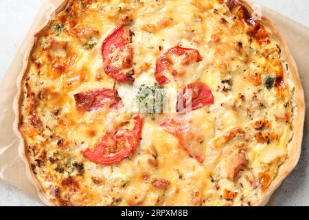 Leckere Quiche mit Käse und Tomaten auf hellgrauem Tisch, Blick von oben Stockfoto