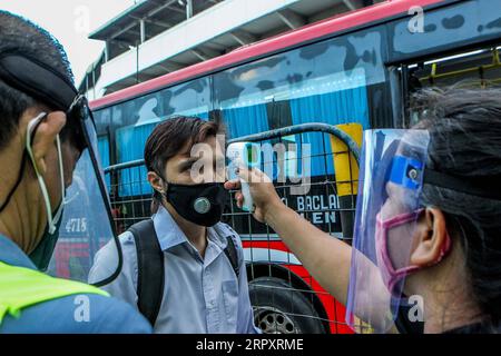 200601 -- MANILA, 1. Juni 2020 Xinhua -- Ein Passagier, der eine Gesichtsmaske trägt, lässt seine Körpertemperatur überprüfen, bevor er am ersten Tag in einen Bus einsteigt, als die COVID-19-Lockdown-Beschränkungen in Manila, den Philippinen, am 1. Juni 2020 weiter gelockert wurden. Der philippinische Präsident Rodrigo Duterte kündigte am 28. Mai an, ab dem 1. Juni weitere Lockdown-Beschränkungen in Metro Manila zu lockern, um die Wiedereröffnung von mehr Unternehmen und Verkehrsmitteln zu ermöglichen. Xinhua/Rouelle Umali PHILIPPINEN-MANILA-COVID-19-LOCKDOWN-EASING PUBLICATIONxNOTxINxCHN Stockfoto