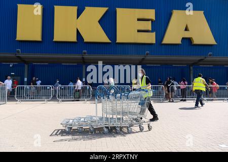 200602 -- LONDON, 2. Juni 2020 Xinhua -- ein IKEA-Mitarbeiter schiebt Wagen an Kunden vorbei, die sich vor dem IKEA-Store in Wembley, London, Großbritannien, am 2. Juni 2020 anstellen. Foto von Ray Tang/Xinhua BRITAIN-LONDON-COVID-19-IKEA-REOPENING PUBLICATIONxNOTxINxCHN Stockfoto