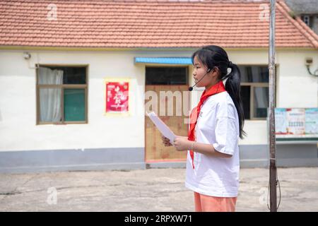 200603 -- LINGCHUAN, 3. Juni 2020 -- Qin Chunlan spricht bei der Flaggenhisserung im Mawuzhai Internat im Lingchuan County, nordchinesische Provinz Shanxi, am 2. Juni 2020. Am 2. Juni kehrten Qin Chunlan, Qin Qiulan und Qin XingWang zur Schule zurück. Früh am Morgen stiegen sie auf das Dreirad ihres Vaters und eilten in die Grundschule des mehr als 10 Kilometer entfernten Mawuzhai-Internats. Die Familie der drei Kinder ist der einzige Haushalt im Dorf Nanbei im Lingchuan County, und die Grundschule ist die einzige Schule im Umkreis von dutzenden Kilometern. Es gibt s Stockfoto