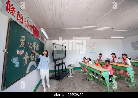 200603 -- LINGCHUAN, 3. Juni 2020 -- Schüler besuchen die erste Klasse, die vom Englischlehrer Chen Yanzi am Mawuzhai Internat in Lingchuan County, Provinz Shanxi, am 2. Juni 2020 gegeben wurde. Am 2. Juni kehrten Qin Chunlan, Qin Qiulan und Qin XingWang zur Schule zurück. Früh am Morgen stiegen sie auf das Dreirad ihres Vaters und eilten in die Grundschule des mehr als 10 Kilometer entfernten Mawuzhai-Internats. Die Familie der drei Kinder ist der einzige Haushalt im Dorf Nanbei im Lingchuan County, und die Grundschule ist die einzige Schule innerhalb eines Radius von Dutzenden von Kil Stockfoto