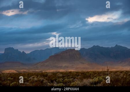 Nugent Mountain mit Silhouetten der Chisos Mountains in der Ferne am stürmischen Morgen in Big Bend Stockfoto