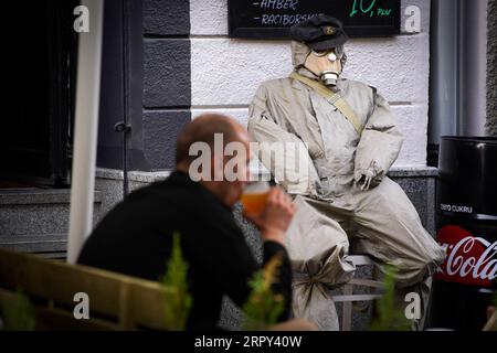 200613 -- PEKING, 13. Juni 2020 -- am 11. Juni 2020 sitzt Ein Mann und trinkt Bier mit einer Schaufensterpuppe, die mit einer Gasmaske ausgestattet ist, die das Äußere der Bar in Warschau, Polen, schmückt. Foto von /Xinhua XINHUA FOTOS DES TAGES JaapxArriens PUBLICATIONxNOTxINxCHN Stockfoto