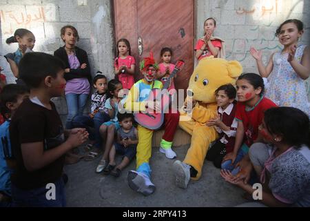 200613 -- PEKING, 13. Juni 2020 -- palästinensische Freiwillige, die als Clown und Bär verkleidet sind, treten für Flüchtlingskinder auf, um ihren Geist in der Stadt Rafah im südlichen Gazastreifen am 12. Juni 2020 zu heben. Foto von /Xinhua XINHUA FOTOS DES TAGES KhaledxOmar PUBLICATIONxNOTxINxCHN Stockfoto