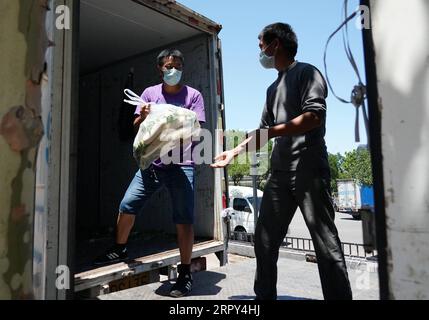 200614 -- PEKING, 14. Juni 2020 -- Gemüsehändler entladen weiße Radieschen an einem der fünf temporären Handelsplätze, die nach der Aussetzung des Xinfadi-Großhandelsmarktes in Peking, der Hauptstadt Chinas, am 14. Juni 2020 benannt wurden. Xinfadi, der größte Großhandelsmarkt mit Obst-, Gemüse- und Fleischlieferungen in Peking, wurde am Samstag zur Desinfektion ausgesetzt, nachdem dort arbeitendes Personal und die Umgebung positiv auf das neuartige Coronavirus getestet haben. Um das Marktangebot zu gewährleisten, wurden spezielle Abschnitte für den Verkauf von Gemüse und Obst mit einer geschlossenen Verwaltung eingerichtet Stockfoto