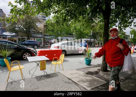 200615 -- VANCOUVER, 15. Juni 2020 Xinhua -- Ein Bewohner geht an einer Terrasse am Straßenrand in North Vancouver, British Columbia, Kanada, 14. Juni 2020 vorbei. Die Kommunalverwaltungen in Metro Vancouver nutzen Straßen in der Region um, indem sie die Fahrspuren auf offene Terrassen am Straßenrand reduzieren, was Fußgängern sicherere Bewegungsfreiheit und räumliche Distanzierung bietet und Unternehmen bei den schwierigen wirtschaftlichen Herausforderungen unterstützt. Foto von Liang Sen/Xinhua CANADA-VANCOUVER-COVID-19-ROADSIDE PATIOS PUBLICATIONxNOTxINxCHN Stockfoto