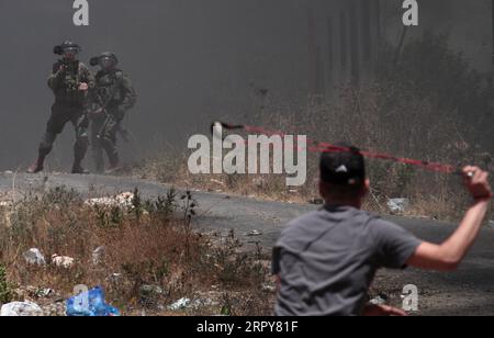 News Themen der Woche KW25 News Bilder des Tages 200619 -- NABLUS, 19. Juni 2020 -- ein palästinensischer Demonstrant verwendet eine Schleuder, um Steine auf israelische Soldaten zu schleudern, nachdem er am 19. Juni 2020 gegen die Ausdehnung jüdischer Siedlungen im Dorf Kufr Qadoom in der Nähe der Stadt Nablus im Westjordanland protestiert hatte. Foto von /Xinhua MIDEAST-NABLUS-CLASHES NidalxEshtayeh PUBLICATIONxNOTxINxCHN Stockfoto