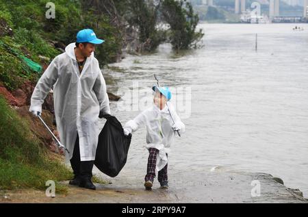 200621 -- PEKING, 21. Juni 2020 -- Ein Vater und sein Sohn pflücken Müll am Jialing River in der Gemeinde Chongqing, Südwestchina, 13. Oktober 2018. WELTVÄTER TAGESBESCHÜTZER, LEHRER UND ENCOURAGER WANGXQUANCHAO PUBLICATIONXNOTXINXCHN Stockfoto