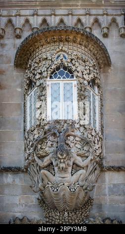 Terrasse des Triton, Nationalpalast von Pena (Palácio da Pena), Sintra, Portugal. Triton, mythologische Halb-Mann, Halb-Fisch-Kreatur, über dem Eingangsbogen zum Palast. Der Eingang ist als „Allegorisches Tor zur Erschaffung der Welt“ bekannt Stockfoto