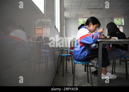 200622 -- HEFEI, 22. Juni 2020 -- Cai Qiyan isst mit ihren Klassenkameraden an der Sanhe Experimental School im Jinzhai County in der ostchinesischen Provinz Anhui, 19. Juni 2020. Cai Qiyan genießt den Blick auf fließende Wolken von einer der Teeplantagen auf den Berggipfeln. Aber der Spaß war auch ein Luxus für den 15-Jährigen, der mit angeborener Skoliose diagnostiziert wurde. Schon in jungen Jahren hatte Qiyan es sehr schwer, ihre Wirbelsäule aufrecht zu halten. In der Tiefe der Dabie-Berge musste Qiyan zwei Stunden auf dem Weg zur Schule und zurück nach Hause verbringen, da es viel länger dauerte, mit einem gebogenen Körper zu laufen. Stockfoto