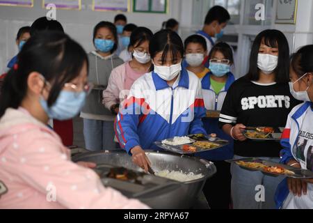 200622 -- HEFEI, 22. Juni 2020 -- Cai Qiyan C isst mit ihren Klassenkameraden an der Sanhe Experimental School im Jinzhai County, ostchinesische Provinz Anhui, 19. Juni 2020. Cai Qiyan genießt den Blick auf fließende Wolken von einer der Teeplantagen auf den Berggipfeln. Aber der Spaß war auch ein Luxus für den 15-Jährigen, der mit angeborener Skoliose diagnostiziert wurde. Schon in jungen Jahren hatte Qiyan es sehr schwer, ihre Wirbelsäule aufrecht zu halten. In der Tiefe der Dabie-Berge musste Qiyan zwei Stunden auf dem Weg zur Schule und zurück nach Hause verbringen, da es viel länger dauerte, mit einem gebogenen Körper zu laufen Stockfoto