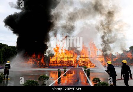 200626 -- YANGON, 26. Juni 2020 -- Feuerwehrmänner sprühen Wasser auf einen brennenden Haufen beschlagnahmter Drogen während einer Zeremonie in Yangon, Myanmar, 26. Juni 2020. Am Freitag wurden in den Regionen Yangon, Mandalay und Shan in Myanmar Drogen im Wert von über 839 Millionen US-Dollar verbrannt, was den Internationalen Tag gegen Drogenmissbrauch und illegalen Handel markierte. MYANMAR-YANGON-DRUG-DESTRUCTION UxAung PUBLICATIONxNOTxINxCHN Stockfoto