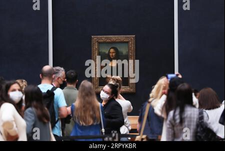 200707 -- PEKING, 7. Juli 2020 -- Besucher, die Gesichtsmasken tragen, schauen sich das Gemälde Mona Lisa im Louvre an, das am Tag der Wiedereröffnung in Paris, Frankreich, am 6. Juli 2020 gezeigt wird. Nach dreieinhalb Monaten Schließung wurde das Louvre, eines der meistbesuchten Museen der Welt, am Montag wieder für die Öffentlichkeit geöffnet, ohne lange Warteschlangen von Besuchern wie vor der COVID-19-Pandemie. XINHUA-FOTOS DES TAGES GaoxJing PUBLICATIONxNOTxINxCHN Stockfoto