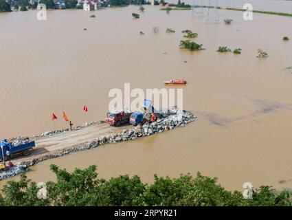 200712 -- POYANG, 12. Juli 2020 -- Luftaufnahme, aufgenommen am 12. Juli 2020, zeigt die Baustelle eines überfallenen Deichs in der Stadt Poyang im Kreis Poyang in der ostchinesischen Provinz Jiangxi. Der Damm eines Flusses in der ostchinesischen Provinz Jiangxi wurde am späten Mittwoch nach anhaltenden sintflutartigen Regenfällen durchbrochen und zwang über 9.000 Einwohner zur Evakuierung. CHINA-JIANGXI-POYANG-DEICHBRUCH CN ZHOUXMI PUBLICATIONXNOTXINXCHN Stockfoto