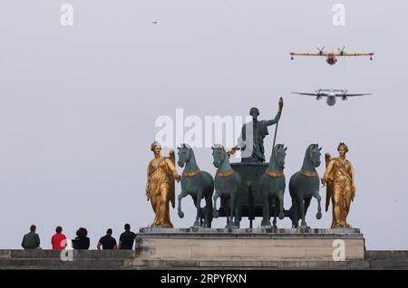200714 -- PARIS, 14. Juli 2020 -- die Leute beobachten das Flugzeug auf dem Arc de Triomphe du Carrousel während der Bastille Day Feier am Place de la Concorde in Paris, Frankreich, 14. Juli 2020. Ohne die traditionelle Militärparade entlang der berühmten Avenue der Champs Elysees und öffentliche Feierlichkeiten führte der französische Präsident Emmanuel Macron am Dienstag den Vorsitz über die Zeremonie des Bastille-Tages, die von der Coronavirus-Krise überschattet wurde. Für die diesjährige Feier wurde die Militärparade, die traditionell große Menschenmassen anlockte, zum ersten Mal seit 1945 abgesagt und durch eine verkleinerte DE ersetzt Stockfoto