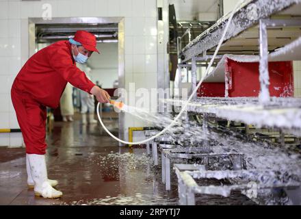 200715 -- PEKING, 15. Juli 2020 -- Ein Mitarbeiter desinfiziert die Fleischsegmentierungslinie der Beijing Ershang Meat Food Group Co., Ltd. In Peking, Hauptstadt von China, 14. Juli 2020. Beijing Ershang Meat Food Group Co., Ltd. Ist eines der führenden Unternehmen, das Fleisch für den Pekinger Markt liefert. Während der COVID-19-Pandemie hat das Unternehmen strenge COVID-19-Präventions- und -Kontrollmaßnahmen entlang der gesamten Lieferkette ergriffen, um die Sicherheit von Fleischerzeugnissen und den regelmäßigen Betrieb seiner Verarbeitungsbetriebe zu gewährleisten, um die Marktnachfrage zu decken. CHINA-PEKING-COVID-19-FLEISCH-LIEFERKETTENDESINFEKTION CN LIXXIN Stockfoto