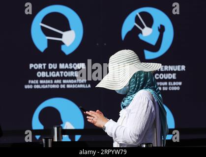 200716 -- PARIS, 16. Juli 2020 -- Eine Frau wartet neben einem Poster, das Menschen an sanitäre Maßnahmen im Eiffelturm in Paris erinnert, Frankreich, 25. Juni 2020. Der französische Premierminister Jean Castex kündigte am Donnerstag an, dass Gesichtsmasken ab nächster Woche in allen öffentlichen Innenräumen obligatorisch sein werden, um die Übertragung von COVID-19 zu verhindern, von dem die Gesundheitsbehörden befürchten, dass sie sich während der Sommerferien schneller ausbreiten könnten. FRANCE-PARIS-COVID-19-MASK-MANDATORY GaoxJing PUBLICATIONxNOTxINxCHN Stockfoto